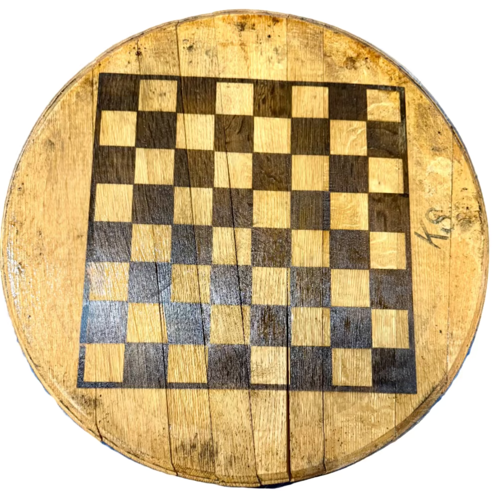 Round wooden chessboard with checkered pattern on a brown surface