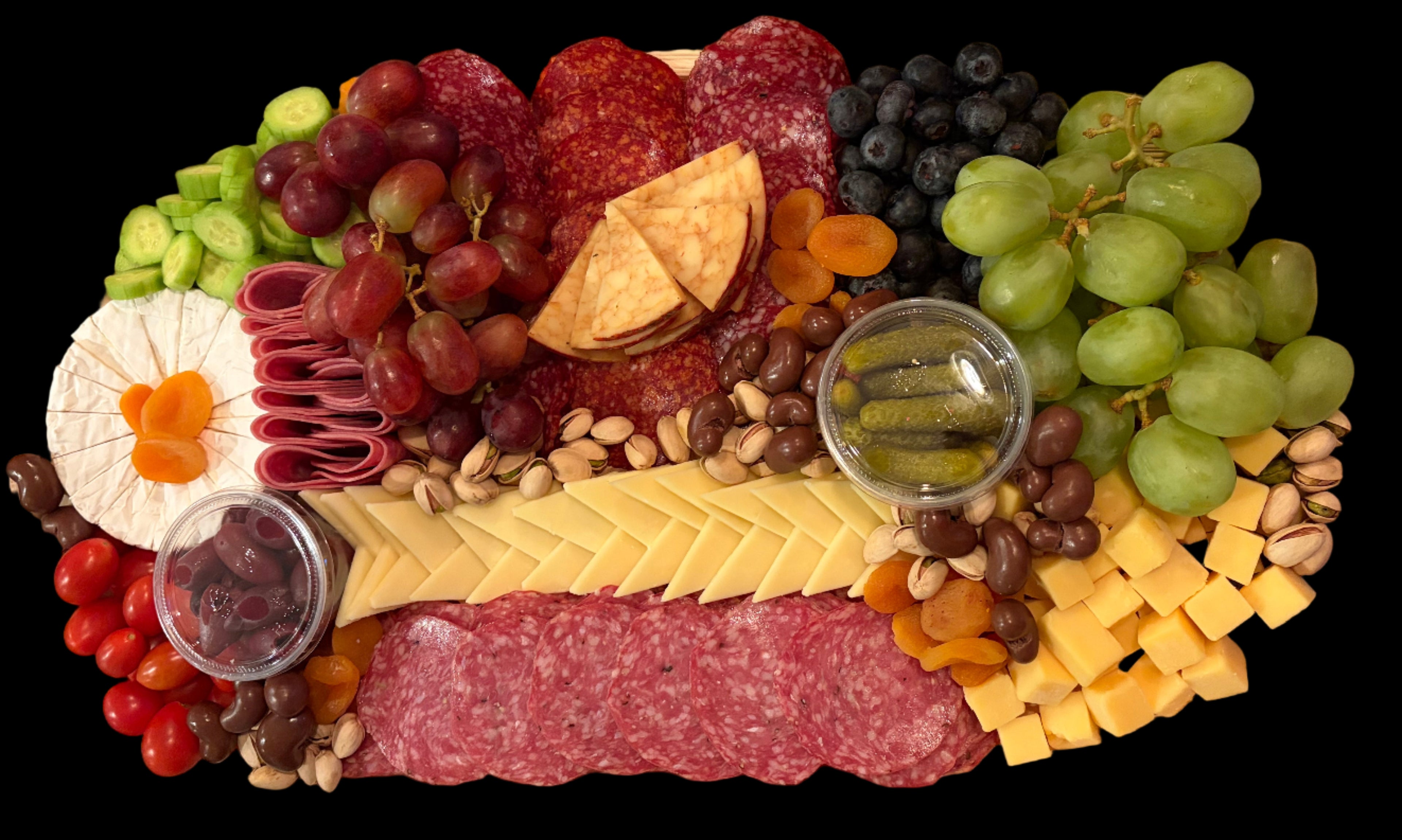 Assorted charcuterie board with meats, cheeses, fruits, and crackers on a decorative table.